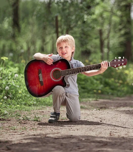 Niño pequeño canta una canción en el camino en el parque Imágenes de stock libres de derechos