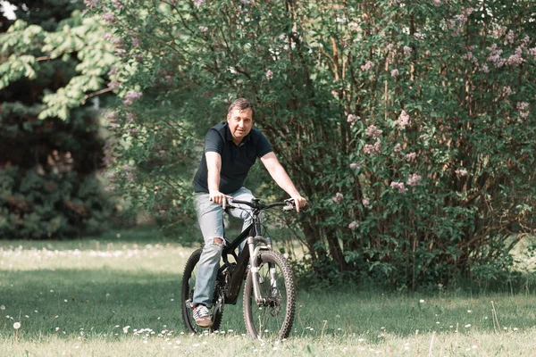 Moderne man op een fiets rijden in de ochtend Park — Stockfoto