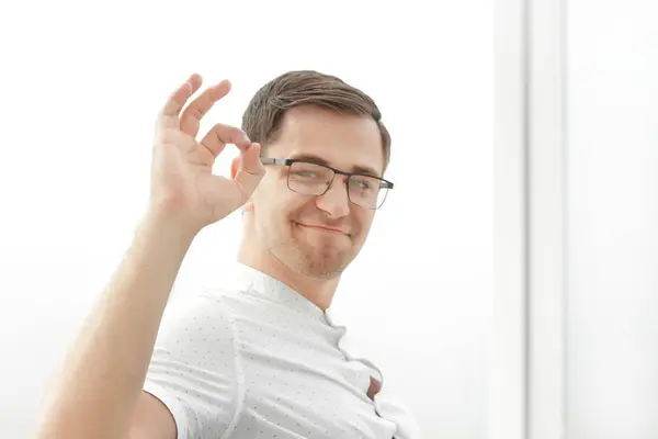 Homem de negócios sorridente em óculos mostrando gesto OK . — Fotografia de Stock