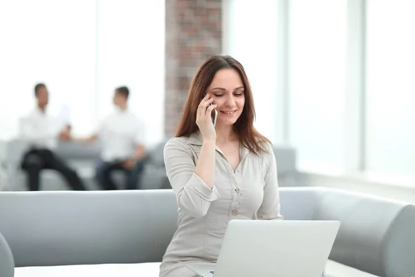 Young business woman communicates with her partners using laptop and smartphone — Stock Photo, Image