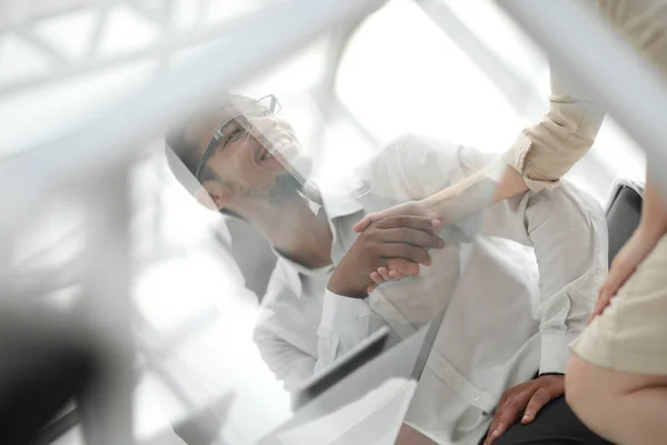 Bottom view.handshake funcionários na mesa no escritório  . — Fotografia de Stock