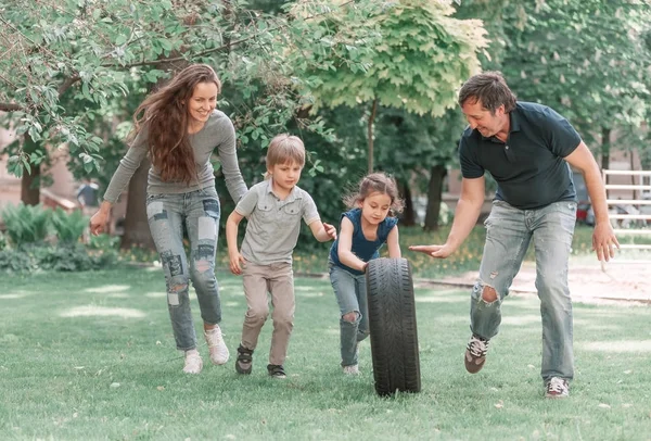 Padres juegan con sus hijos en el parque infantil cerca de la casa —  Fotos de Stock