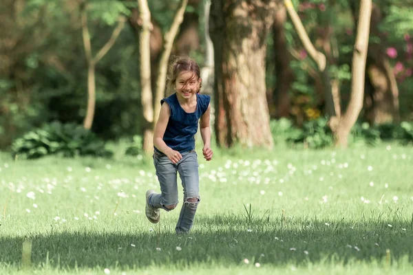 Menina feliz correndo através do prado em um dia de verão . — Fotografia de Stock