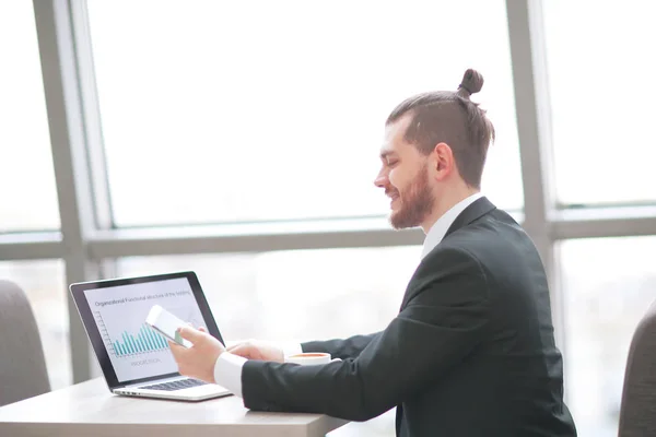 Homme d'affaires occasionnel travaillant avec mobile et ordinateur portable dans un bureau moderne — Photo
