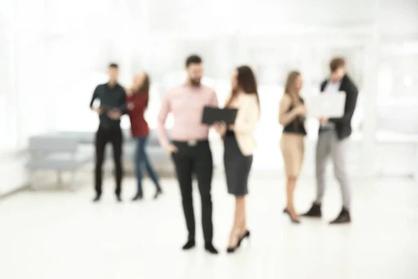 Verschwommenes Bild einer Gruppe von Geschäftsleuten, die sich in der Bürolobby unterhalten. Unternehmenshintergrund — Stockfoto