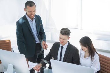 İş ekibi iş yerinde iş belgelerini tartışıyor.