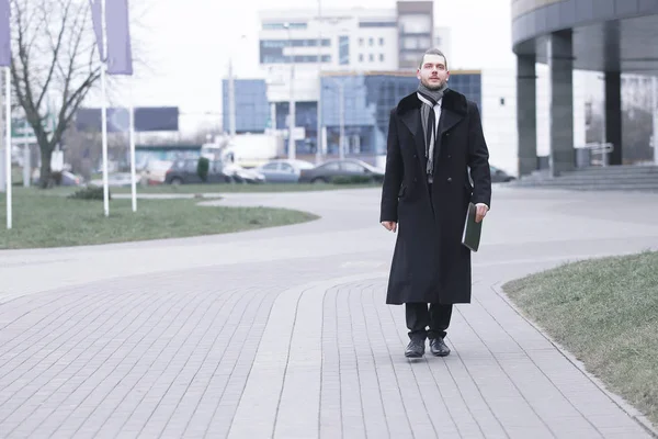 Zakenman in warme kleren lopend onderaan de straat van de stad. — Stockfoto