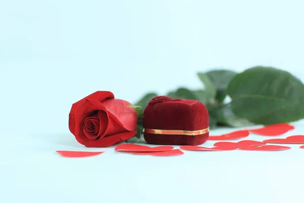 Кольцо в красной коробке с красной розой на белом фоне — стоковое фото