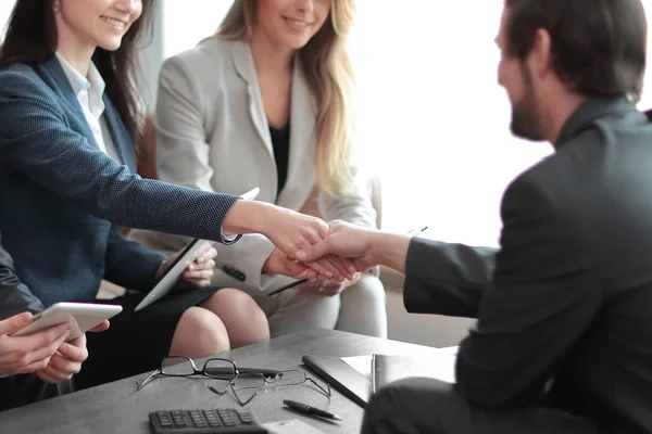 Handshake obchodních partnerů za stůl v moderní kanceláři. — Stock fotografie