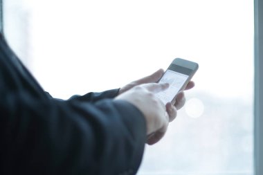 yakın çekim. bir işadamı bir smartphone çalışma tablosu yakın dururken ofiste kullanır.