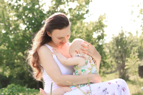 Szczęśliwy matki i córki, siedząc na ławce w city Park — Zdjęcie stockowe