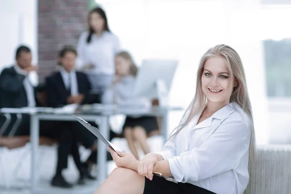 Kvinnlig assistent med av protokollet från mötet på bakgrunden av kontoret — Stockfoto