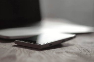 yakın çekim. bulanık görüntü bir cep telefonu ve dizüstü bilgisayar masaüstü