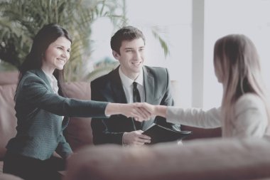 İki iş kadını el ele tutuşur, masada otururlar.