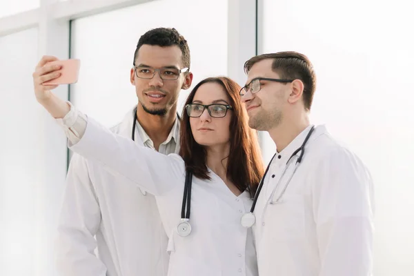 Groep van jonge artsen nemen van selfies in de lobby van het ziekenhuis. — Stockfoto