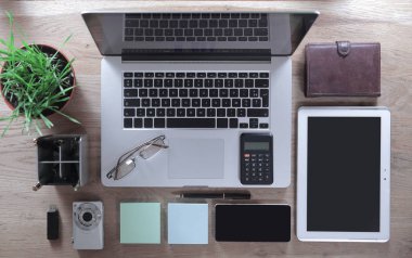 Üstten Görünüm. Ofis donanımı, gözlük ve ofis malzemeleri ahşap bir masaya