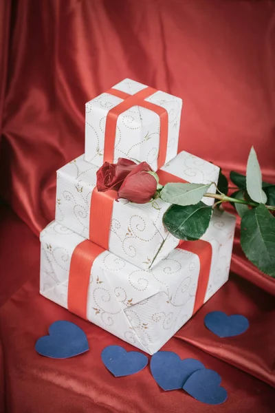 Подарочная коробка и роза на красном фоне. — стоковое фото