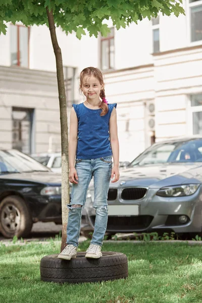 Portrait of a little girl standing in the city yard Stock Image