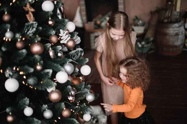 Uzavřít up.two sestry v pohotovosti vánoční stromeček — Stock fotografie
