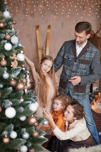 Šťastná rodina zdobí vánoční stromek v obývacím pokoji. — Stock fotografie
