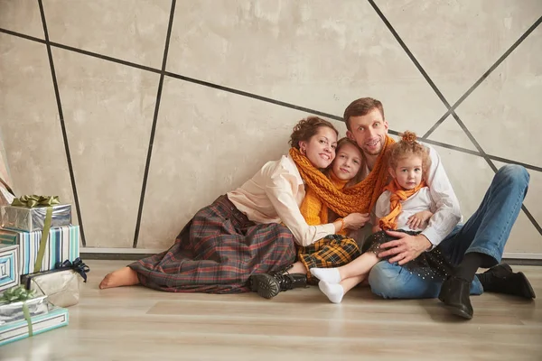 Pais felizes com suas filhas sentadas no chão em um novo apartamento — Fotografia de Stock