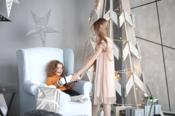 Menina dá a sua irmã mais nova um presente de Natal — Fotografia de Stock