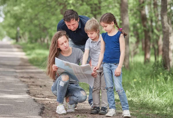 Familj med två barn använda kortet när du reser — Stockfoto