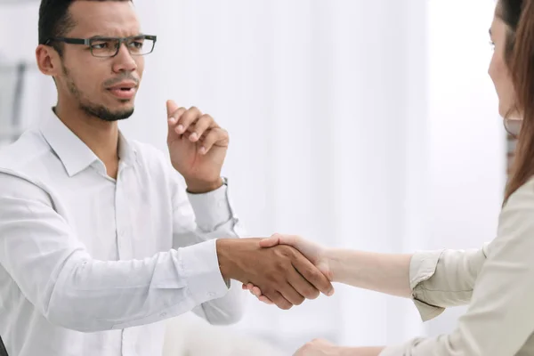 Jonge mensen schudden handen, zittend in de office-lobby — Stockfoto