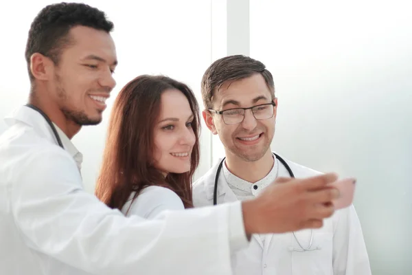 Equipe de médicos estagiários tomando selfies no lobby do hospital — Fotografia de Stock