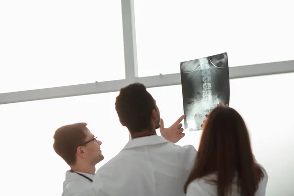Vista trasera. doctores mirando la radiografía del paciente  . — Foto de Stock