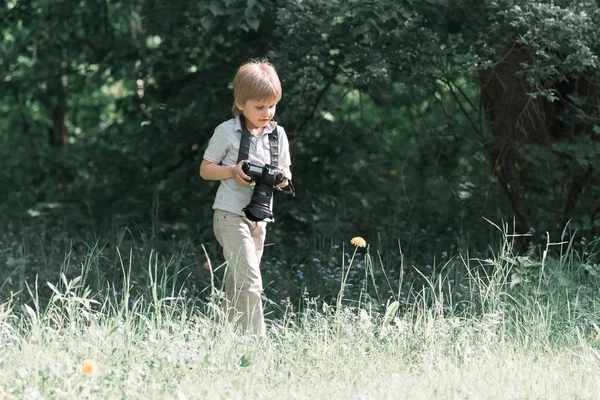 Pojke med en kamera i parken. — Stockfoto