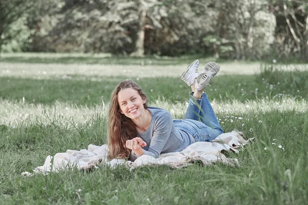 Young woman lying on lawn in summer day — Stock Photo, Image