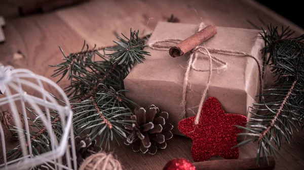 Presente de Natal, paus de canela e decoração de Natal em fundo de madeira — Fotografia de Stock