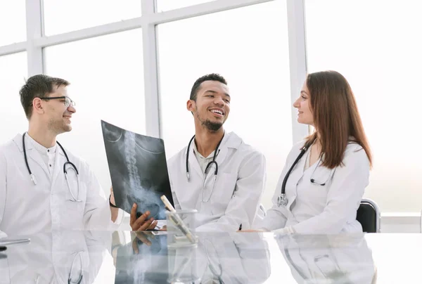 Medische collega's bespreken x-ray, zitten aan de tafel van office — Stockfoto