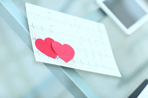 Cardiogram en twee rode papier hart op tafel — Stockfoto