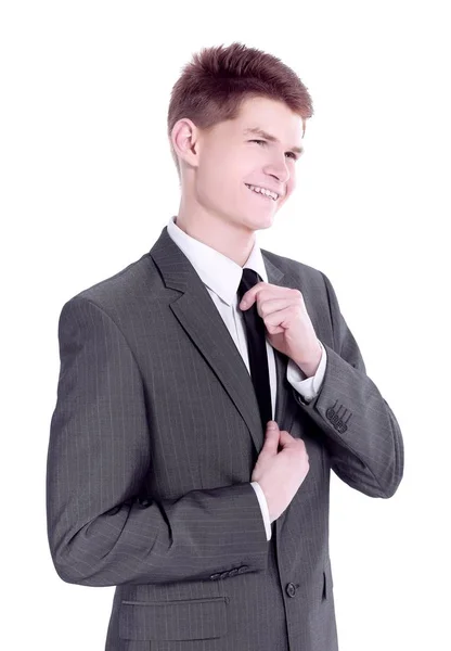 Νεαρός επιχειρηματίας προσαρμόζει τη γραβάτα του. Απομονωμένος σε λευκό. — Φωτογραφία Αρχείου