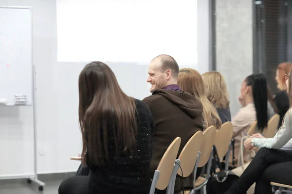 Audiencia en la sala de conferencias mirando una pantalla en blanco — Foto de Stock
