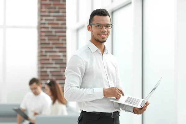 Empleado escribiendo en un ordenador portátil de pie en la oficina . — Foto de Stock