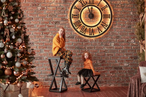 Graziose sorelle sedute in un elegante soggiorno la vigilia di Natale — Foto Stock
