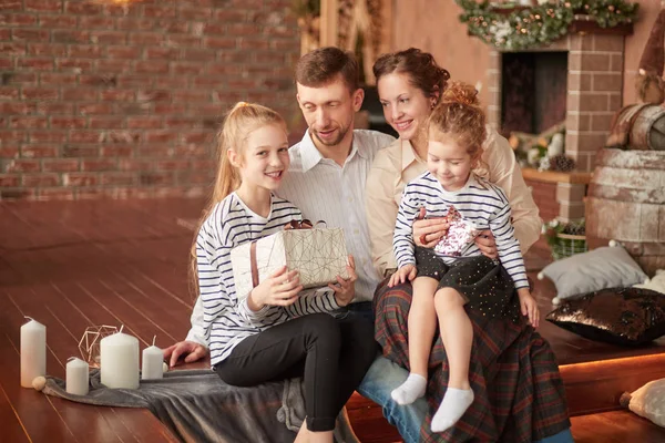 Familia feliz con regalos de Navidad sentado en una acogedora sala de estar . — Foto de Stock