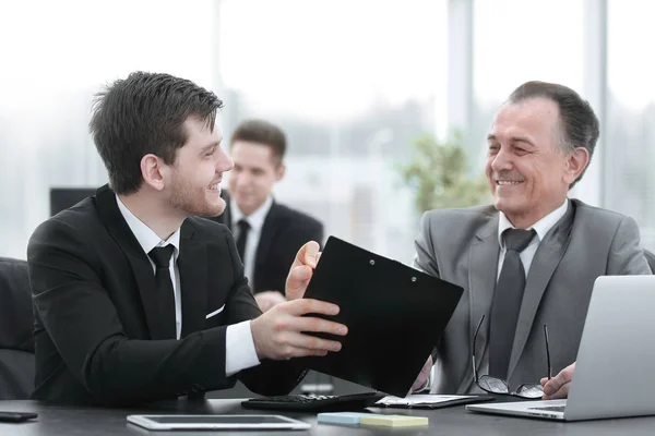 Volwassen zakenman financiële documenten met een jonge collega bespreken. — Stockfoto