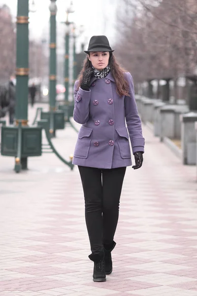 Şehir Bulvarı yürüyüş şapka ve sonbahar paltolu şık genç kadın — Stok fotoğraf