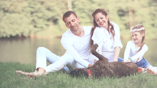 happy family with pet dog at picnic in a Sunny summer day. pregn