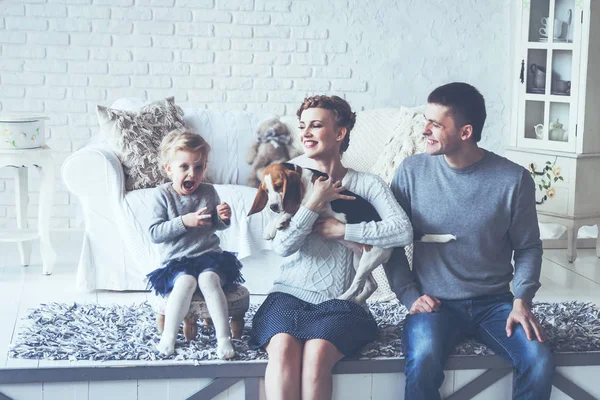 Retrato de una familia feliz y su mascota en un acogedor salón — Foto de Stock