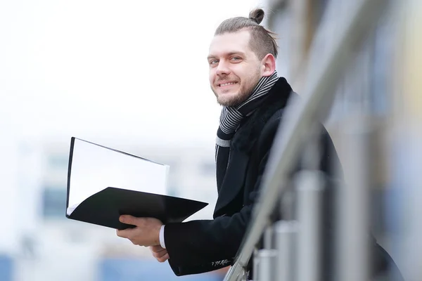 Smiling business man in warm clothes with papers — Stock Photo, Image