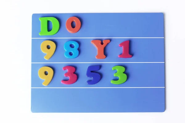 Plastic magnetic colored english alphabet on blue background — Stock Photo, Image