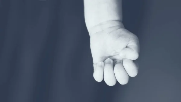 Hand eines Neugeborenen, das in den Armen seines Vaters liegt — Stockfoto