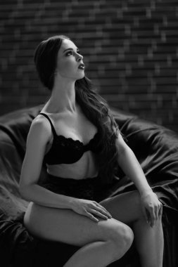 güzel genç kadın bir sandalyede oturan siyah iç çamaşırı