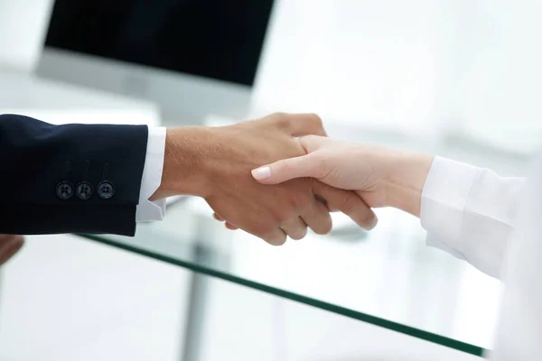 Close-up. Os parceiros financeiros apertando as mãos sobre uma mesa  . — Fotografia de Stock