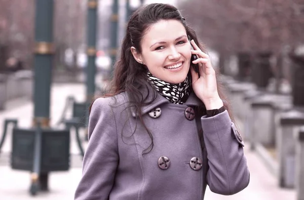 Fecha. uma jovem mulher falando em um telefone celular em uma rua da cidade — Fotografia de Stock